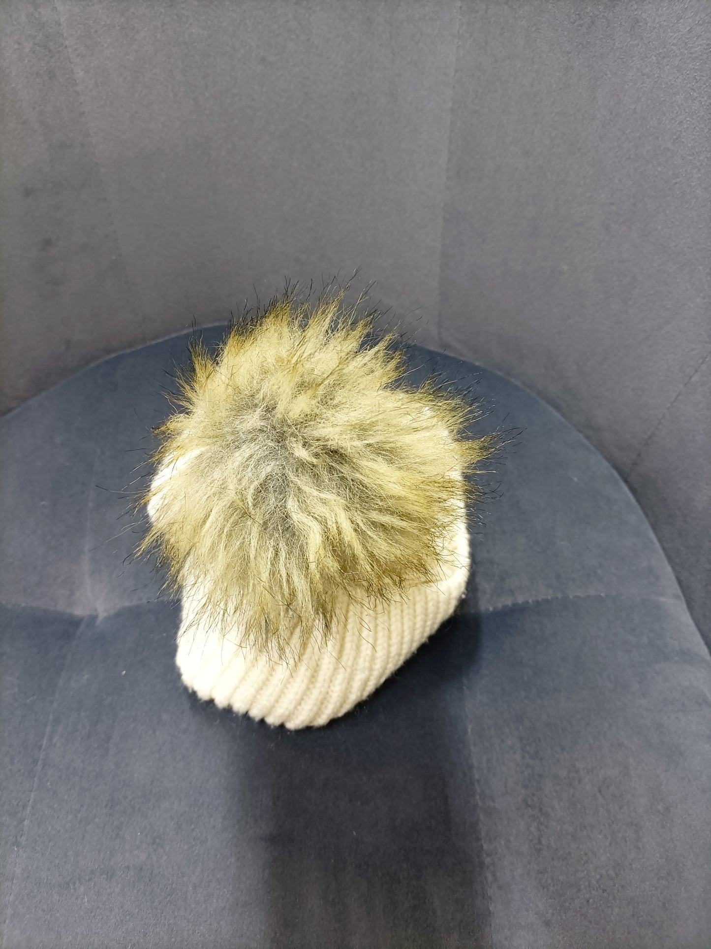 Bonnet beige avec pompon en fausse fourrure